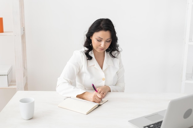 Indian woman beautician takes notes in office cosmetologist business woman or doctor concept