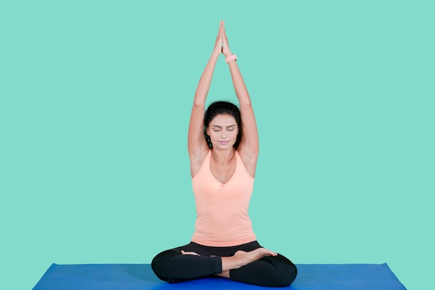 Indian woman doing yoga exercise in the studio