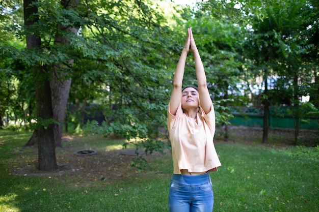 Indian woman doing yoga in outdoor summer park