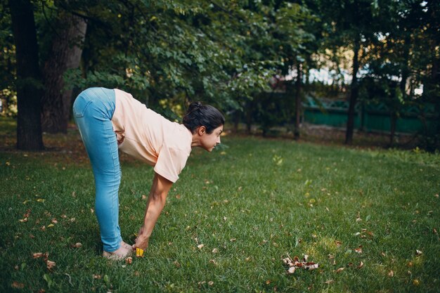 屋外の夏の公園でヨガをしているインドの女性