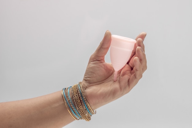 An Indian  woman  hand holding reusable silicon Menstrualcup