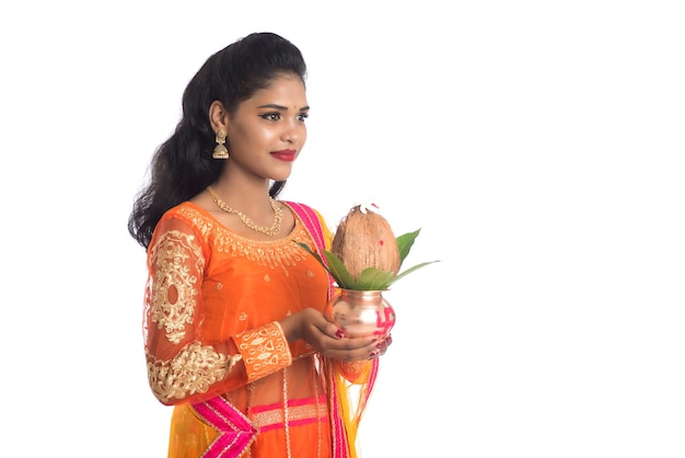 Indian Woman holding a traditional copper Kalash with coconut and mango leaf with floral decoration, Essential in Indian Hindu Festival and worship