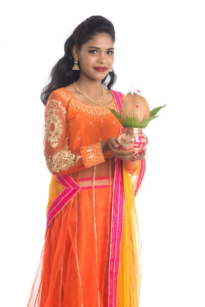 Indian Woman holding a traditional copper Kalash with coconut and mango leaf with floral decoration