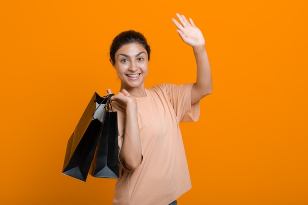 Indian woman holds shopping bags in hands. Sale and Black Friday concept.