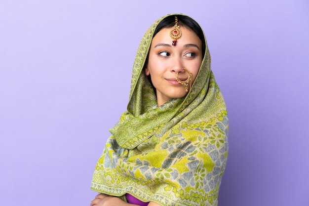 무기와 보라색 벽에 고립 된 인도 여자 넘어와 행복
