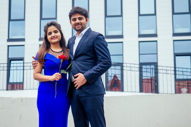 Indian woman in long evening blue dress spinding romantic time together with lover handsome boyfriend europe urban downtown city.