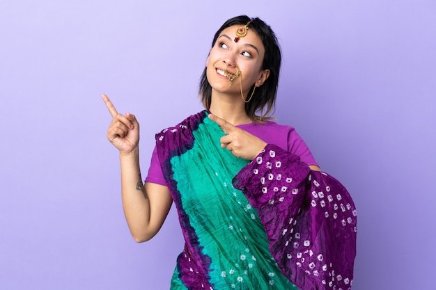 Indian woman on purple wall pointing with the index finger a great idea