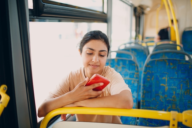 Indian woman ride in public transport bus using mobile phone