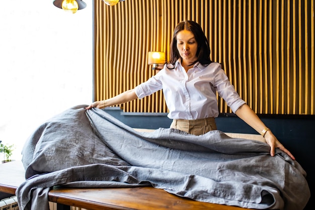 Indian woman setting the table for dining in day light room