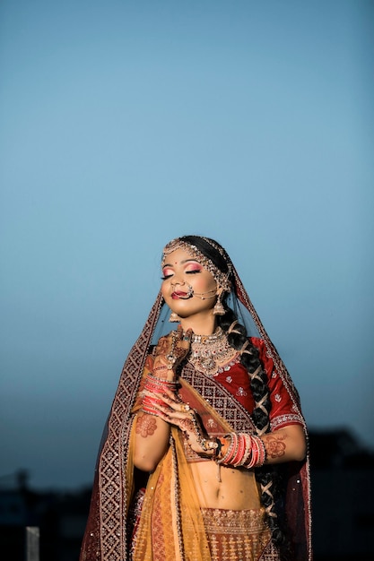 Indian woman with beautiful smile and wearing the bridal lengha and bridal jewellery