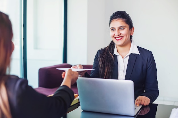 Indian woman working in a bank as a relationship manager issuing loan approval to the customer