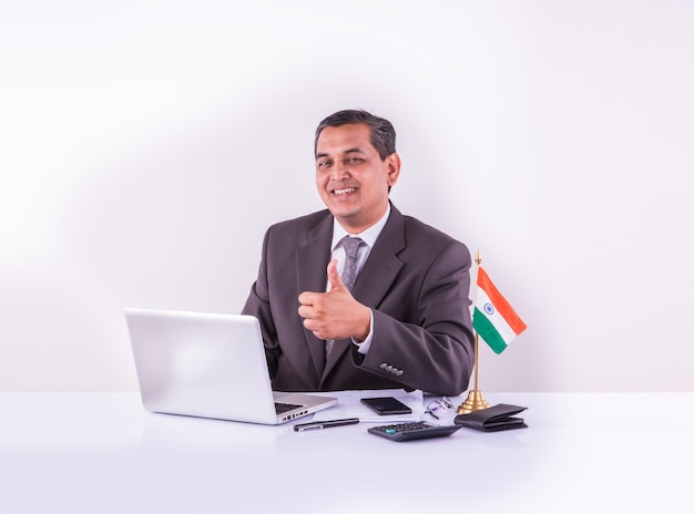 Indian young businessman or accountant with laptop calculator and Indian flag