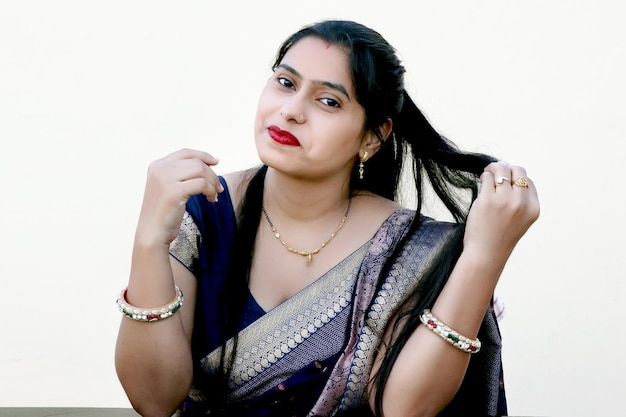 Indian young woman with hand touching her wavy long hair Portrait over white background