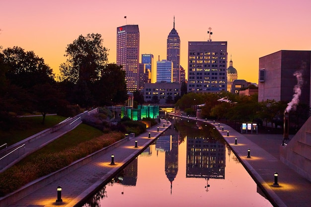 Photo indianapolis skyline at sunset with reflective canal waters