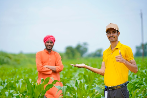 Indiase agronoom met boer op groen landbouwveld.