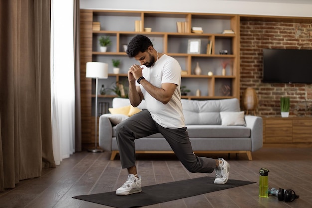 Indiase atleet in sportkleding doet sit-ups in de woonkamer