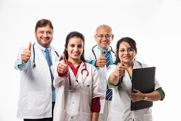 Indiase Aziatische artsen groepsfoto met succes of duimen omhoog teken. staande geïsoleerd op een witte achtergrond. selectieve focus