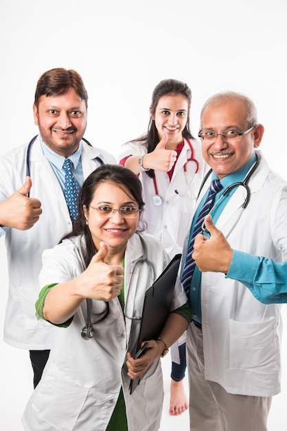 Indiase Aziatische artsen groepsfoto met succes of duimen omhoog teken. staande geïsoleerd op een witte achtergrond. selectieve focus