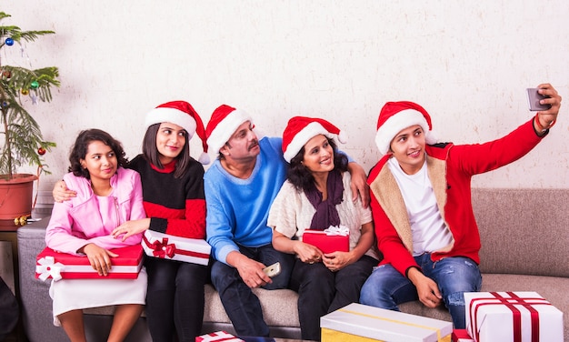 Indiase Aziatische jonge familie viert Kerstmis met cadeau terwijl ze Santa Hat dragen