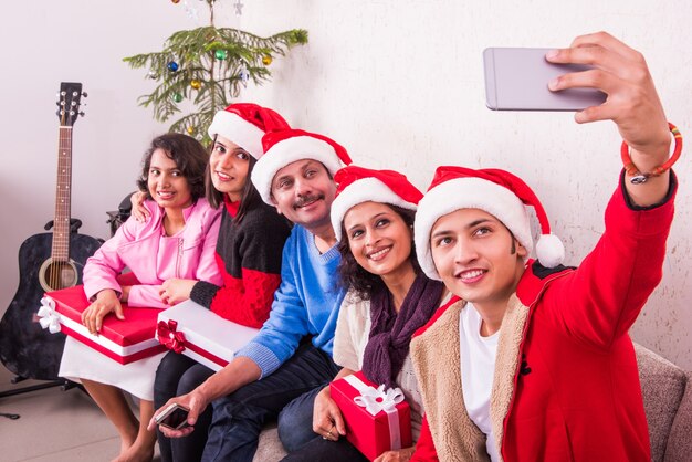 Indiase Aziatische jonge familie viert Kerstmis met cadeau terwijl ze Santa Hat dragen