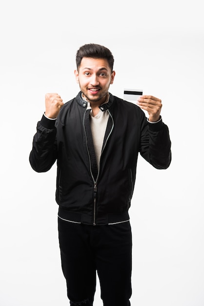 Indiase Aziatische man met creditcard of bankpas of elektronische plastic pasje, geïsoleerd op witte achtergrond