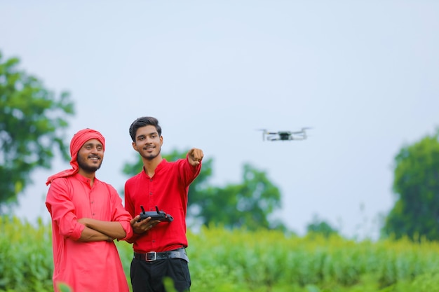 Indiase boer en agronoom met behulp van drone op landbouwgebied