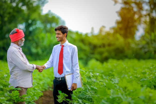 Indiase boer met agronoom op katoenveld, met wat informatie op tabblad