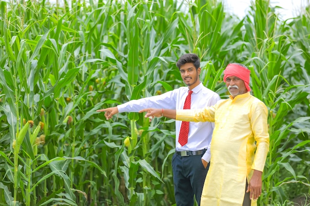 Indiase boer met agronoom op maïsveld