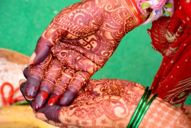 Indiase bruid die handen mehndi-ontwerp toont op bruiloft