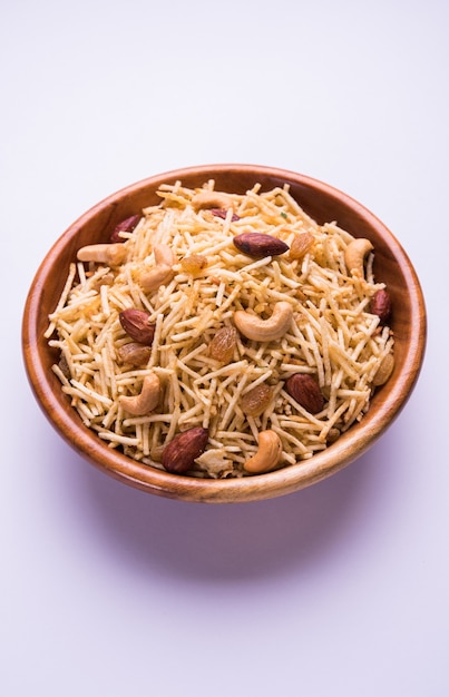 Indiase gefrituurde Falahari chivda ook bekend als vasten of Upwas chiwada gemaakt met aardappel en droog fruit voor Navaratri of een hindoeïstische vrat. Geserveerd in een houten kom. Selectieve focus