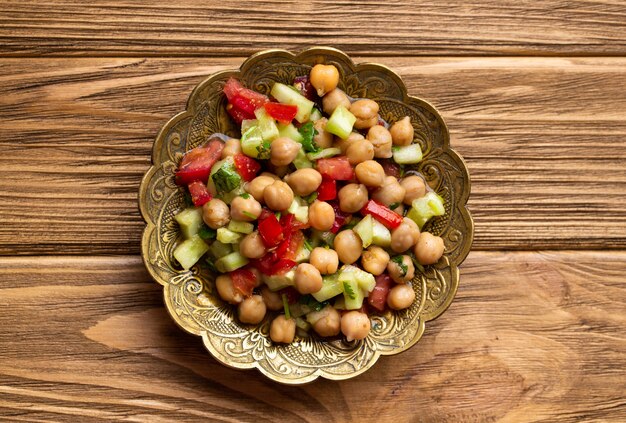 Indiase gezonde salade met kikkererwten en groenten op houten rustieke achtergrond. Gezonde vegetarische Indiase maaltijd. Bovenaanzicht