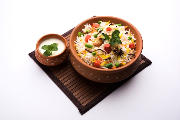 Indiase groentepulav of biryani gemaakt van basmatirijst, geserveerd in een terracotta schaal. selectieve focus