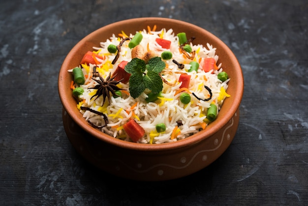 Indiase groentepulav of biryani gemaakt van basmatirijst, geserveerd in een terracotta schaal. selectieve focus