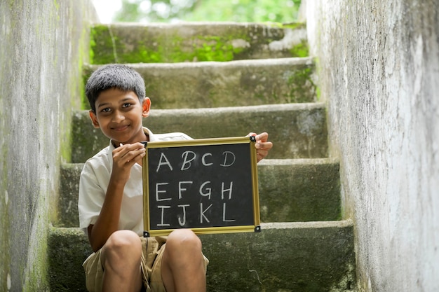 Indiase kind ABCD alfabet schrijven op schoolbord