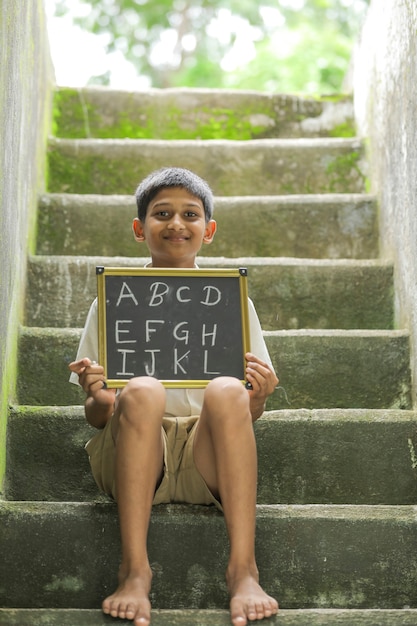 Indiase kind ABCD alfabet schrijven op schoolbord