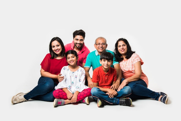Indiase kinderen met ouders en grootouders, zittend geïsoleerd op witte achtergrond, studio-opname