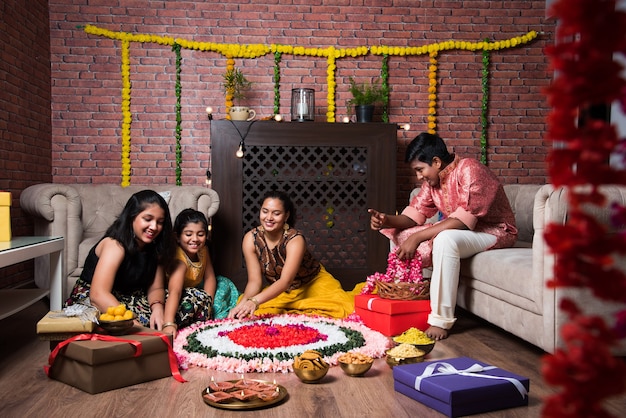 Indiase kinderen vieren Diwali, Deepawali, Bhai Dooj of Rakhi of Raksha Bandhan met bloemrangoli, geschenken, diya