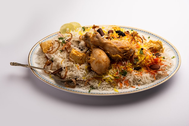 Indiase Kip Biryani geserveerd in een terracotta kom met yoghurt op witte achtergrond. selectieve focus