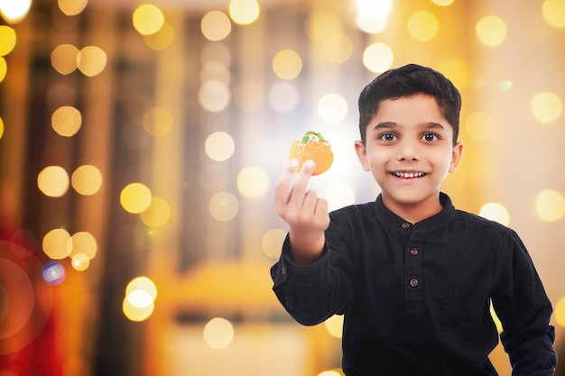 Indiase kleine jongens dragen traditionele Calibrating Diwali Dussehra Navratri en houden geschenkdozen en snoepjes voor smartphones bij de hand