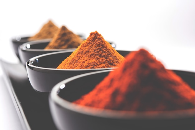 Indiase kleurrijke kruiden. Groepsfoto van vier Indiase basiskruiden zoals rauwe rode peper, kurkuma, koriander en komijnpoeder. selectieve focus