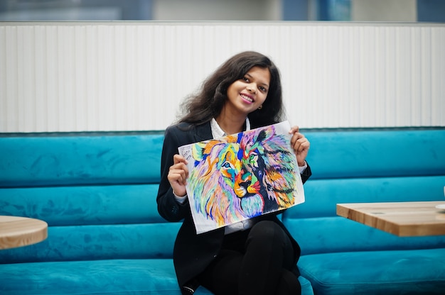 Indiase kunstenaar vrouw draagt formele verf foto, zittend in café.