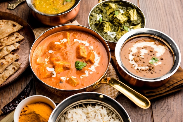 Indiase lunch of diner hoofdgerecht eten in groep omvat Paneer Butter Masala, Dal Makhani, Palak Paneer, Roti, Rice etc, Selectieve focus