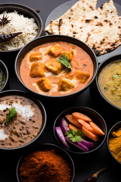 Indiase lunch of diner hoofdgerecht eten in groep omvat Paneer Butter Masala, Dal Makhani, Palak Paneer, Roti, Rice etc, Selectieve focus