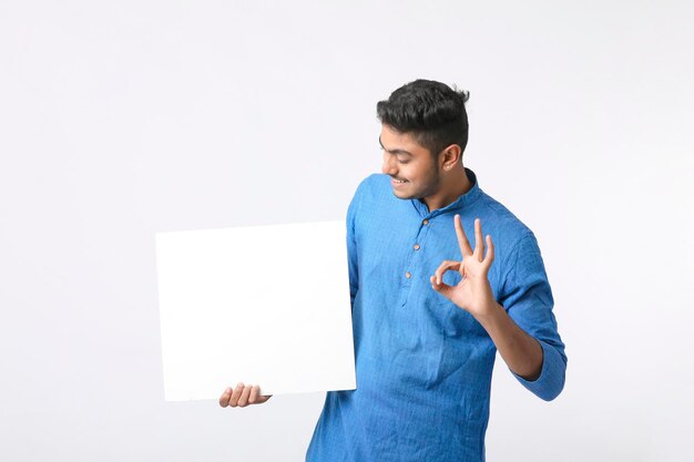 Indiase man die een wit bord vasthoudt, aanbiedingen op het festivalseizoen promoot terwijl hij traditionele kleding draagt, staande op een witte achtergrond.