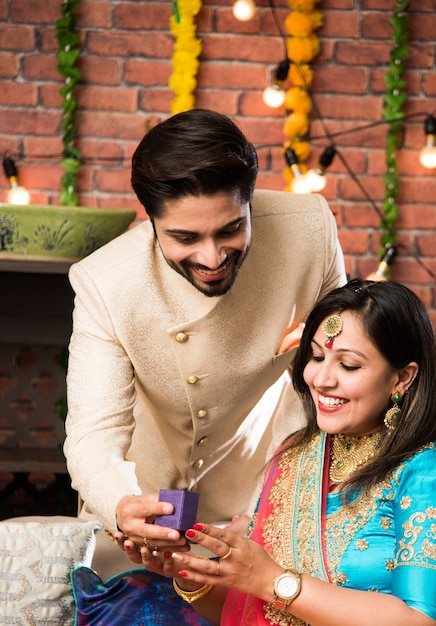 Indiase man die verrassingsgeschenk geeft aan vrouw, sieraden op Diwali of huwelijksverjaardag, selectieve focus