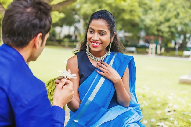 Indiase man geeft franjipani bloemen aan zijn verloofde