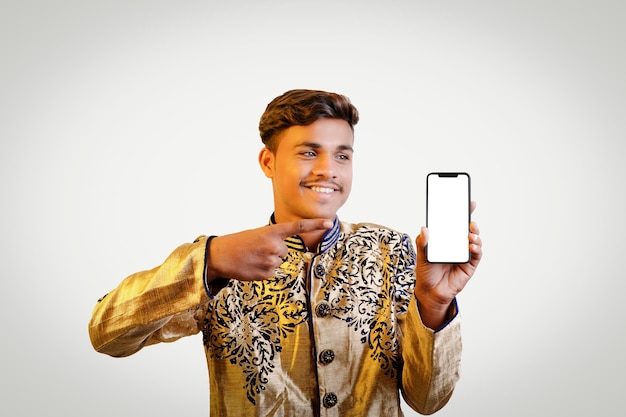 Indiase man in etnische kleding met mobiel scherm Een geïsoleerde achtergrond