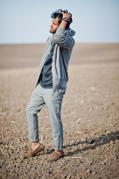 Indiase man in vrijetijdskleding poseerde alleen op het veld