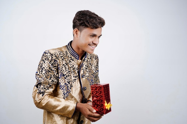 Indiase man met verrassingsgeschenkdozen en lege plaat op DIWALI of bruiloft of festivals terwijl hij traditionele kleding draagt die geïsoleerd op een witte achtergrond staat