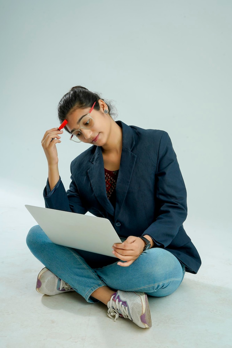 Foto indiase meisjes zitten met een laptop geïsoleerd in wit